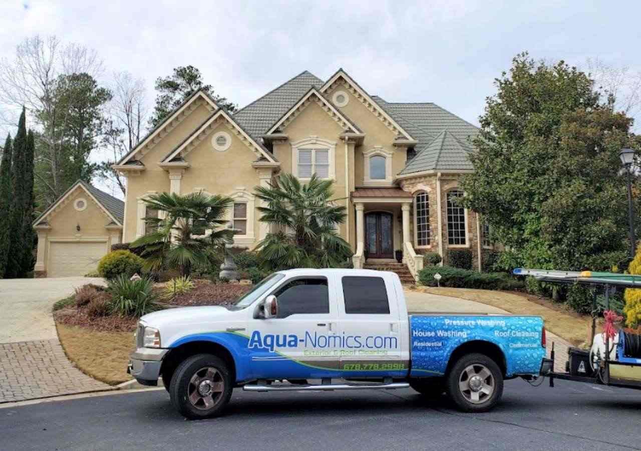 Aqua-Nomics Pressure Washing And Roof Cleaning Van Ready For Service At A Client's Home